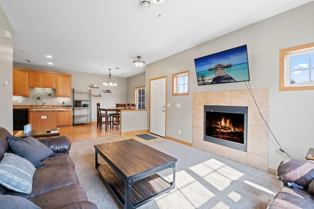 living room with a chandelier, recessed lighting, a wealth of natural light, and a tile fireplace