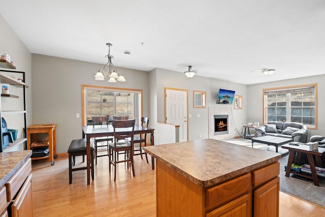 kitchen featuring a wealth of natural light, light wood-type flooring, a kitchen island, and a chandelier