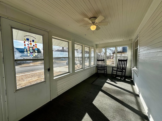 sunroom featuring wooden ceiling and a ceiling fan