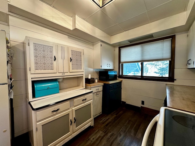 kitchen featuring dark wood finished floors, range with electric cooktop, light countertops, and black microwave