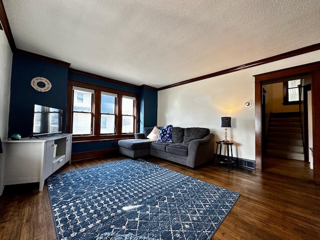 living room featuring a textured ceiling, wood finished floors, crown molding, baseboards, and stairs