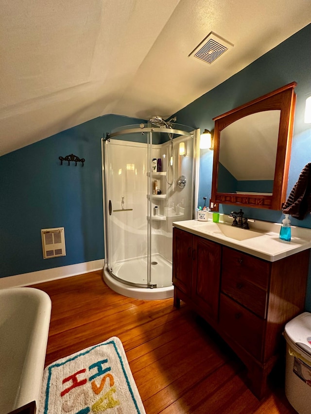 bathroom with vanity, visible vents, a shower stall, vaulted ceiling, and wood-type flooring