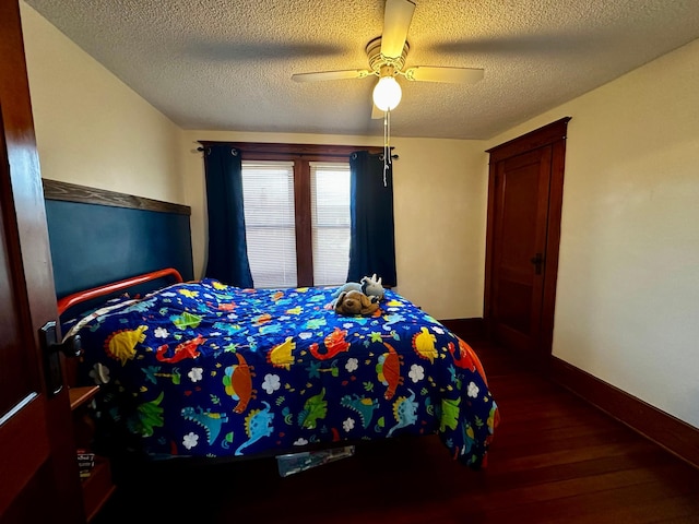 bedroom with a textured ceiling, wood finished floors, baseboards, and ceiling fan