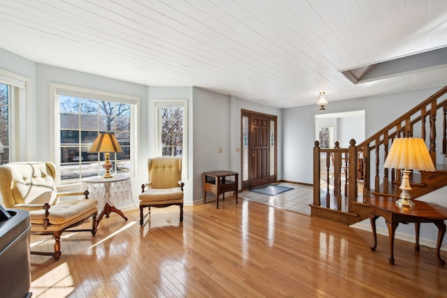 foyer entrance with stairs, light wood-style flooring, and baseboards