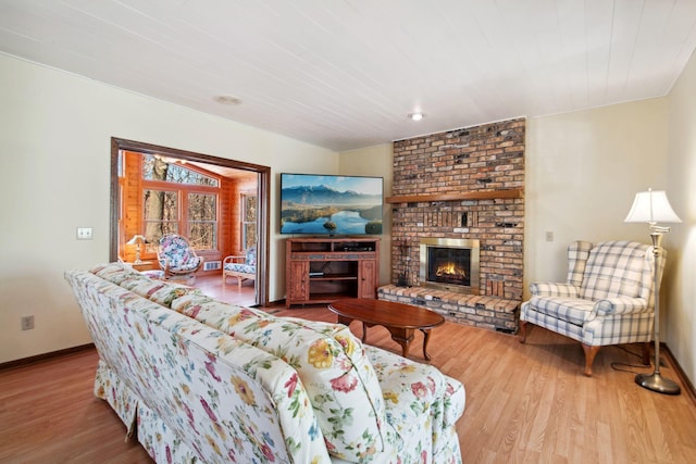 living area featuring a fireplace, wood finished floors, and baseboards