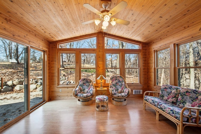 sunroom / solarium featuring a ceiling fan, vaulted ceiling, and wood ceiling