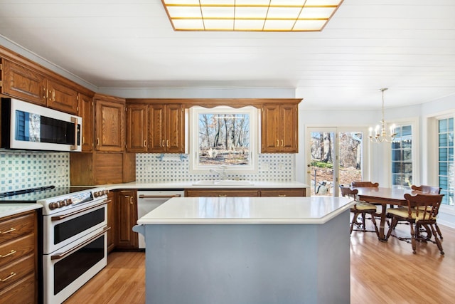 kitchen with a sink, light wood-type flooring, white appliances, and light countertops