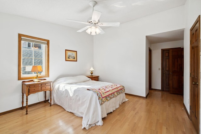 bedroom featuring a ceiling fan, baseboards, and light wood finished floors