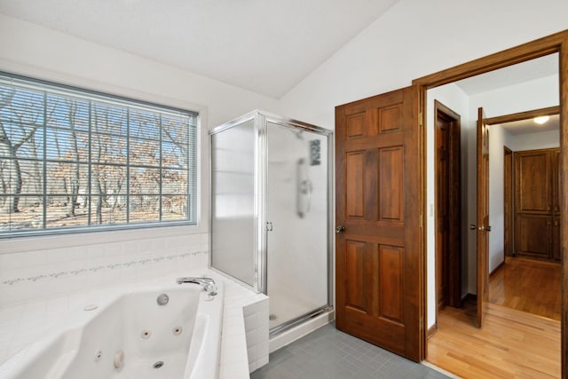 full bathroom featuring a stall shower, a whirlpool tub, and vaulted ceiling