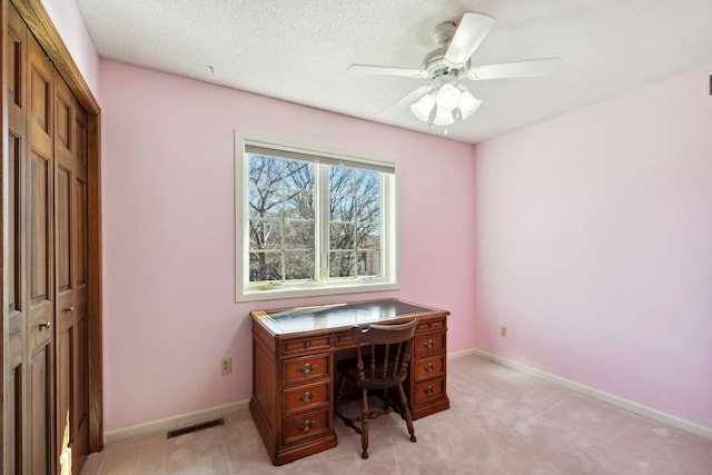 office featuring visible vents, baseboards, light colored carpet, and a ceiling fan