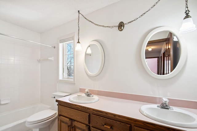 full bathroom with double vanity, toilet,  shower combination, and a sink