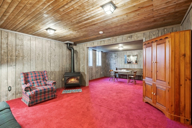 living area featuring carpet flooring, wooden ceiling, and a wood stove