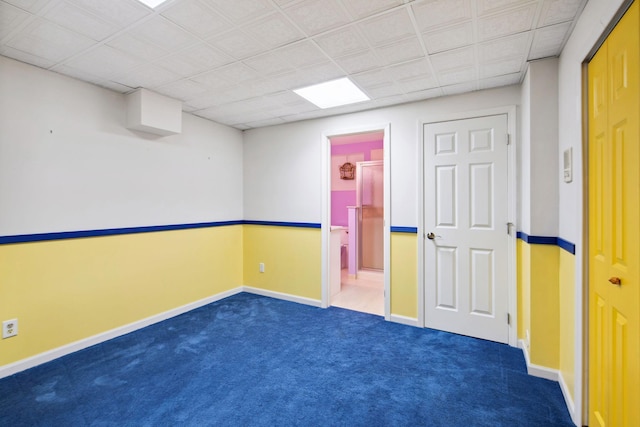 empty room featuring baseboards and dark carpet