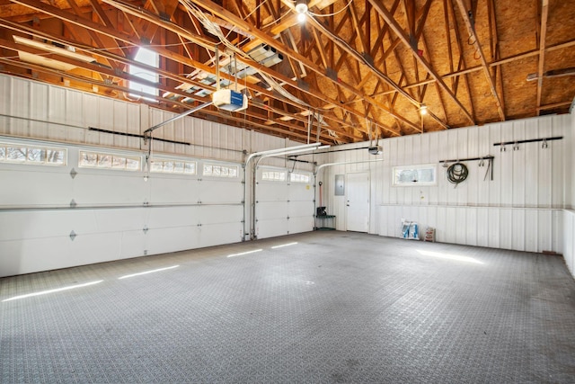 garage with electric panel, a garage door opener, and metal wall