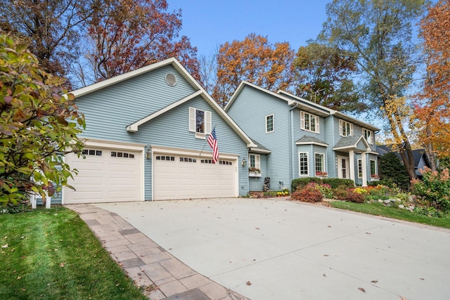 view of front of home with a garage, concrete driveway, and a front yard