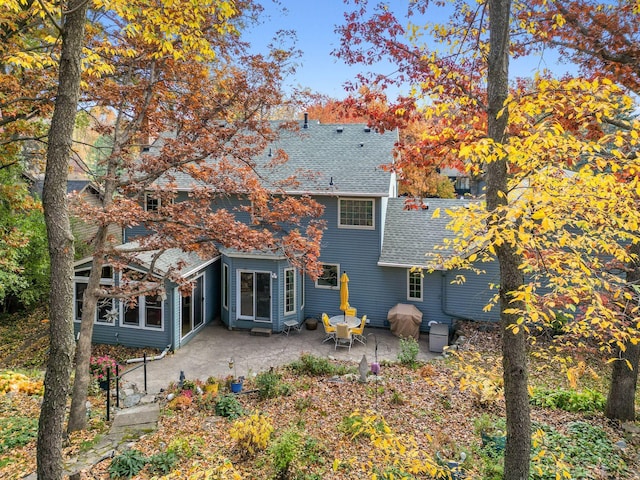 back of property featuring a patio and a shingled roof