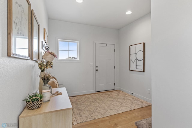 foyer with recessed lighting, baseboards, and wood finished floors