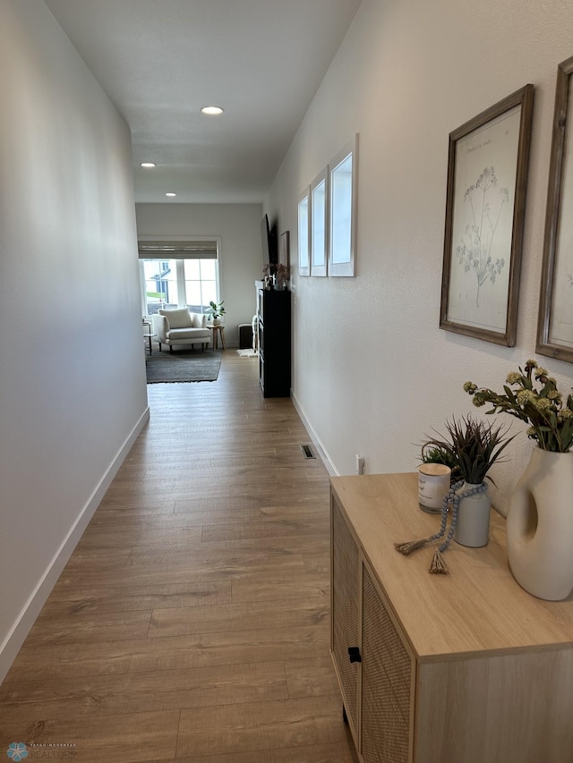 corridor with visible vents, recessed lighting, baseboards, and wood finished floors