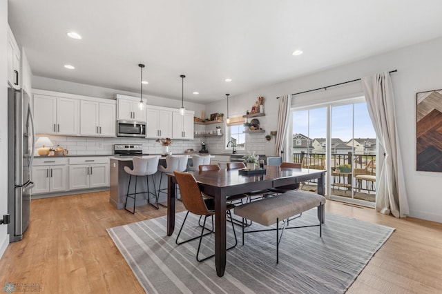 dining room with recessed lighting, light wood-style flooring, and baseboards