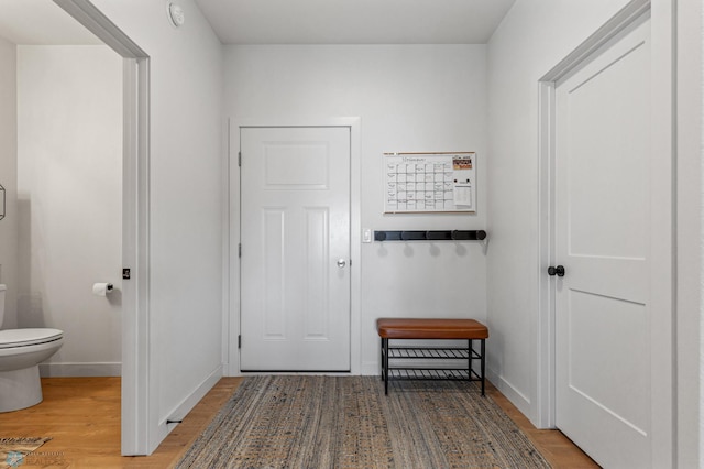 hall featuring wood finished floors and baseboards