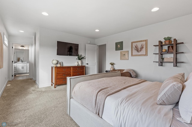 bedroom with recessed lighting, baseboards, light carpet, and ensuite bathroom