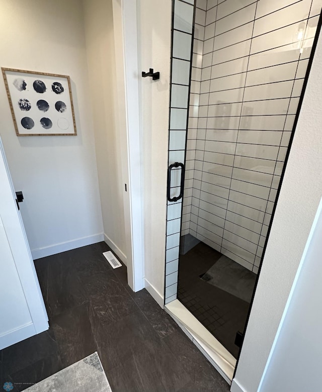 bathroom with baseboards and a stall shower