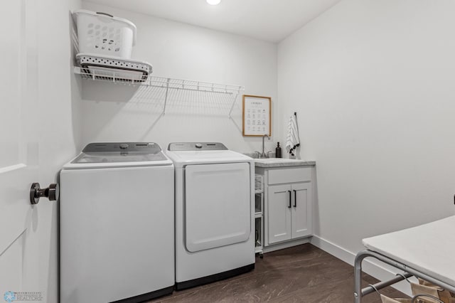 laundry area featuring washer and clothes dryer, cabinet space, baseboards, and a sink