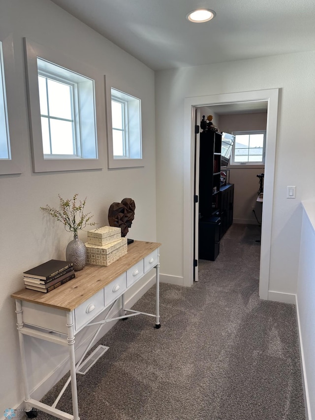 hall featuring recessed lighting, visible vents, dark carpet, and baseboards