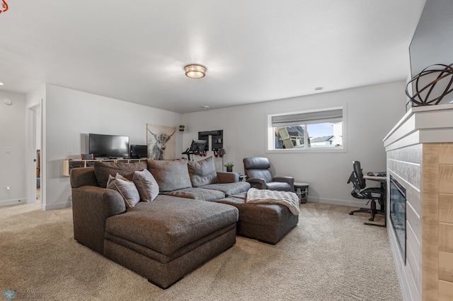 living area with a tiled fireplace, carpet flooring, and baseboards