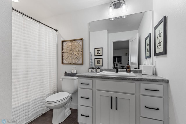 bathroom featuring toilet, vanity, and tile patterned flooring