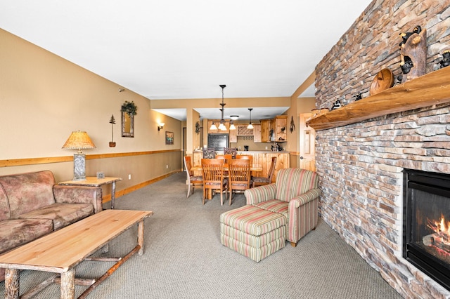 living room with baseboards, light carpet, and a stone fireplace