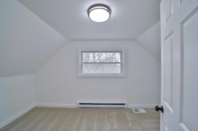 additional living space featuring visible vents, baseboards, lofted ceiling, and baseboard heating