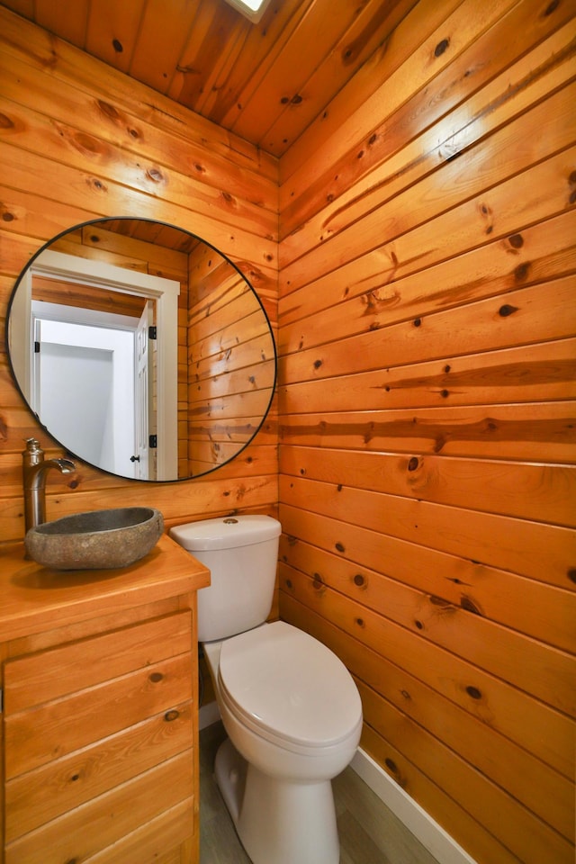 bathroom with wood finished floors, wooden walls, toilet, and wooden ceiling