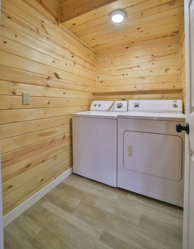 laundry area with wooden walls, laundry area, separate washer and dryer, wooden ceiling, and light wood-type flooring