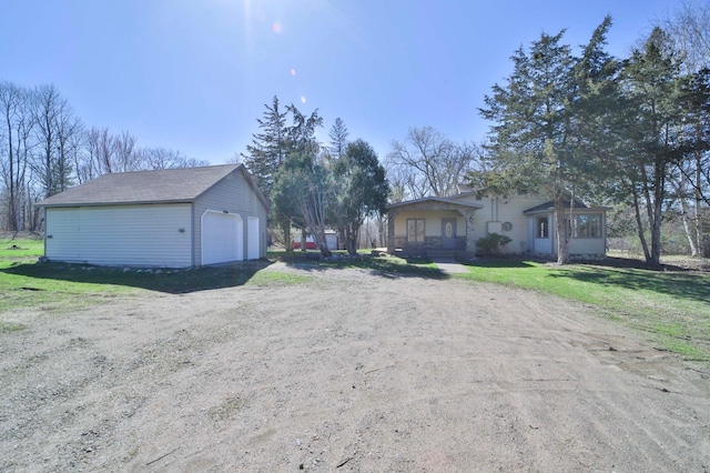 exterior space with a detached garage, an outdoor structure, and a lawn