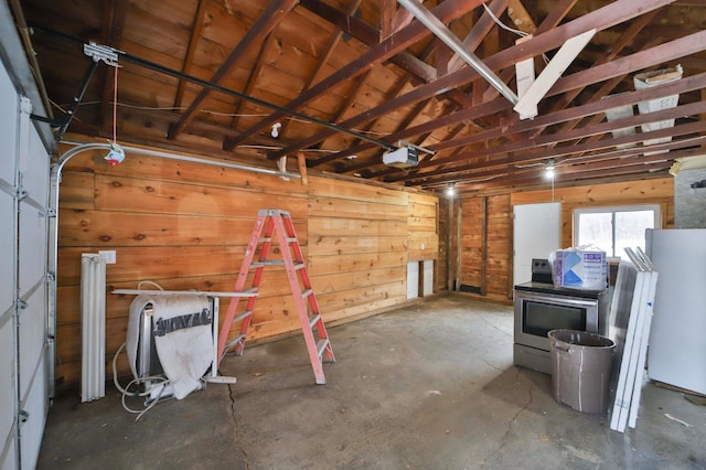 garage with wooden walls, fridge, and a garage door opener