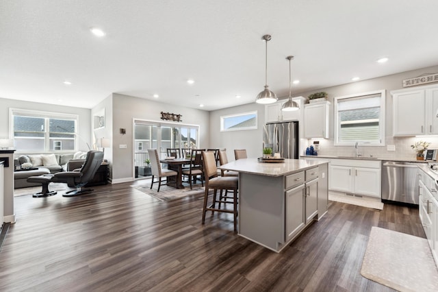 kitchen with a kitchen island, stainless steel appliances, dark wood-type flooring, and open floor plan