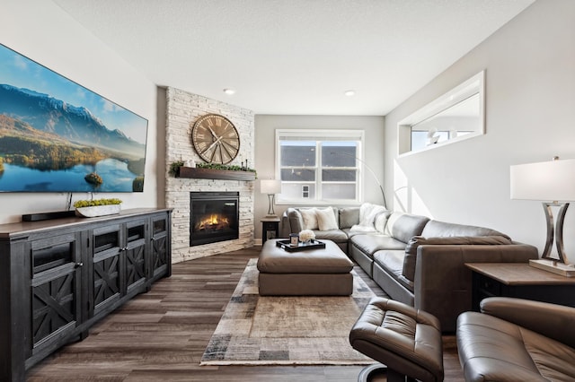 living area with dark wood finished floors, a fireplace, and a textured ceiling