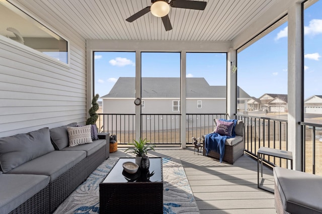 sunroom / solarium featuring a ceiling fan and a residential view