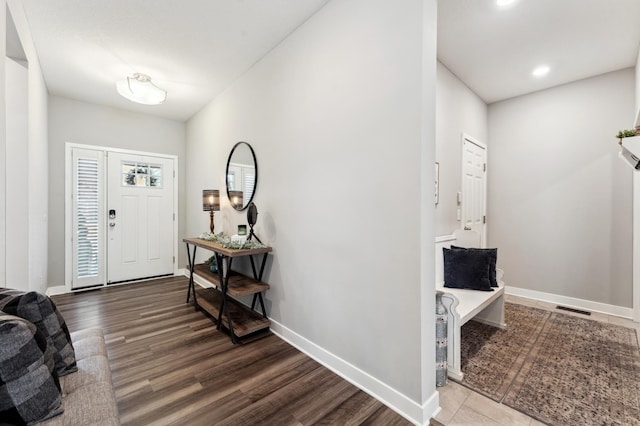 entryway featuring visible vents, baseboards, and wood finished floors