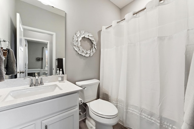 bathroom with vanity, curtained shower, and toilet