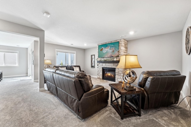 carpeted living room with baseboards and a large fireplace