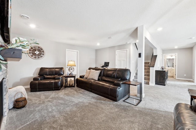 living room with baseboards, recessed lighting, stairs, a stone fireplace, and light colored carpet