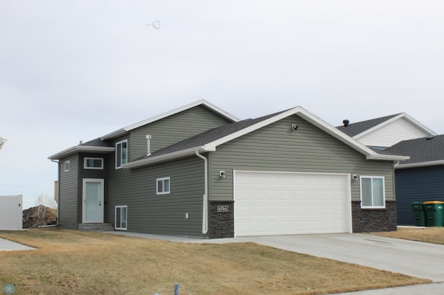 view of property exterior featuring a garage, stone siding, a yard, and driveway