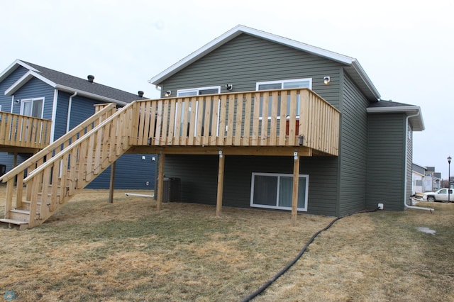 back of house featuring central AC unit, a lawn, and a wooden deck