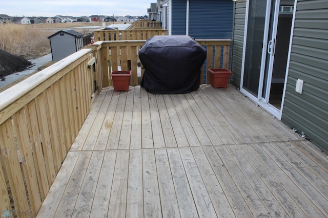 wooden terrace with area for grilling and a residential view