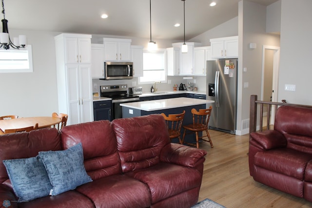 kitchen featuring light countertops, white cabinets, open floor plan, and stainless steel appliances