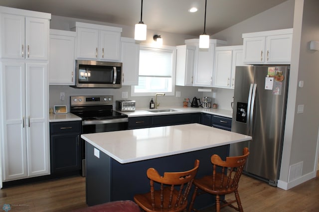 kitchen featuring a breakfast bar, a sink, light countertops, white cabinets, and appliances with stainless steel finishes