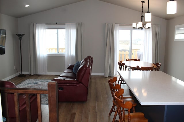 living area with light wood finished floors, a healthy amount of sunlight, and vaulted ceiling