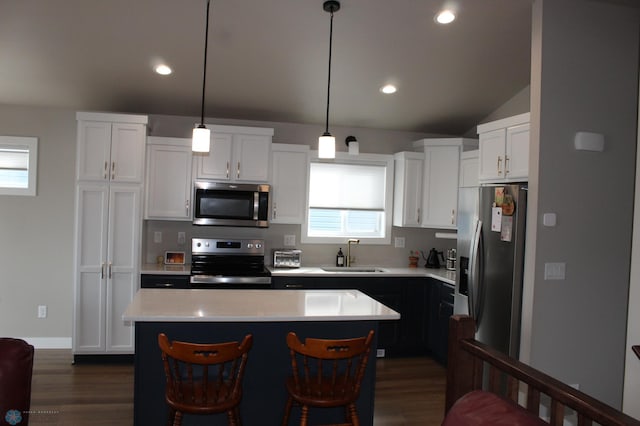 kitchen featuring light countertops, a kitchen island, appliances with stainless steel finishes, and a sink